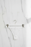 Witte kanten slip op hanger met marmeren achtergrond